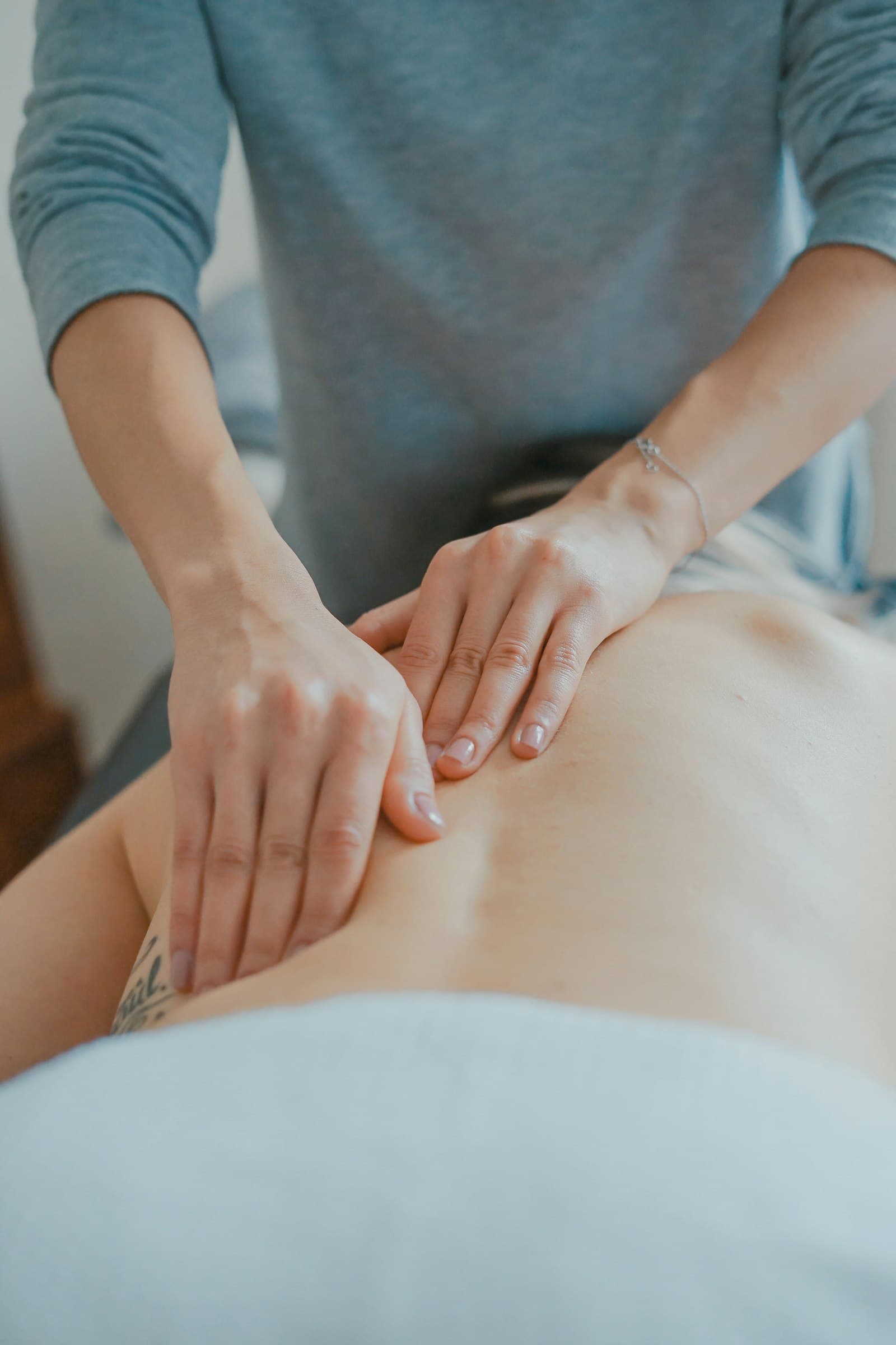 Massage therapist working with both hands on a client's lower back